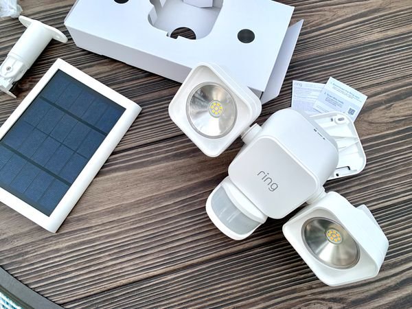 Ring Solar Floodlight with its packaging on a wood floor