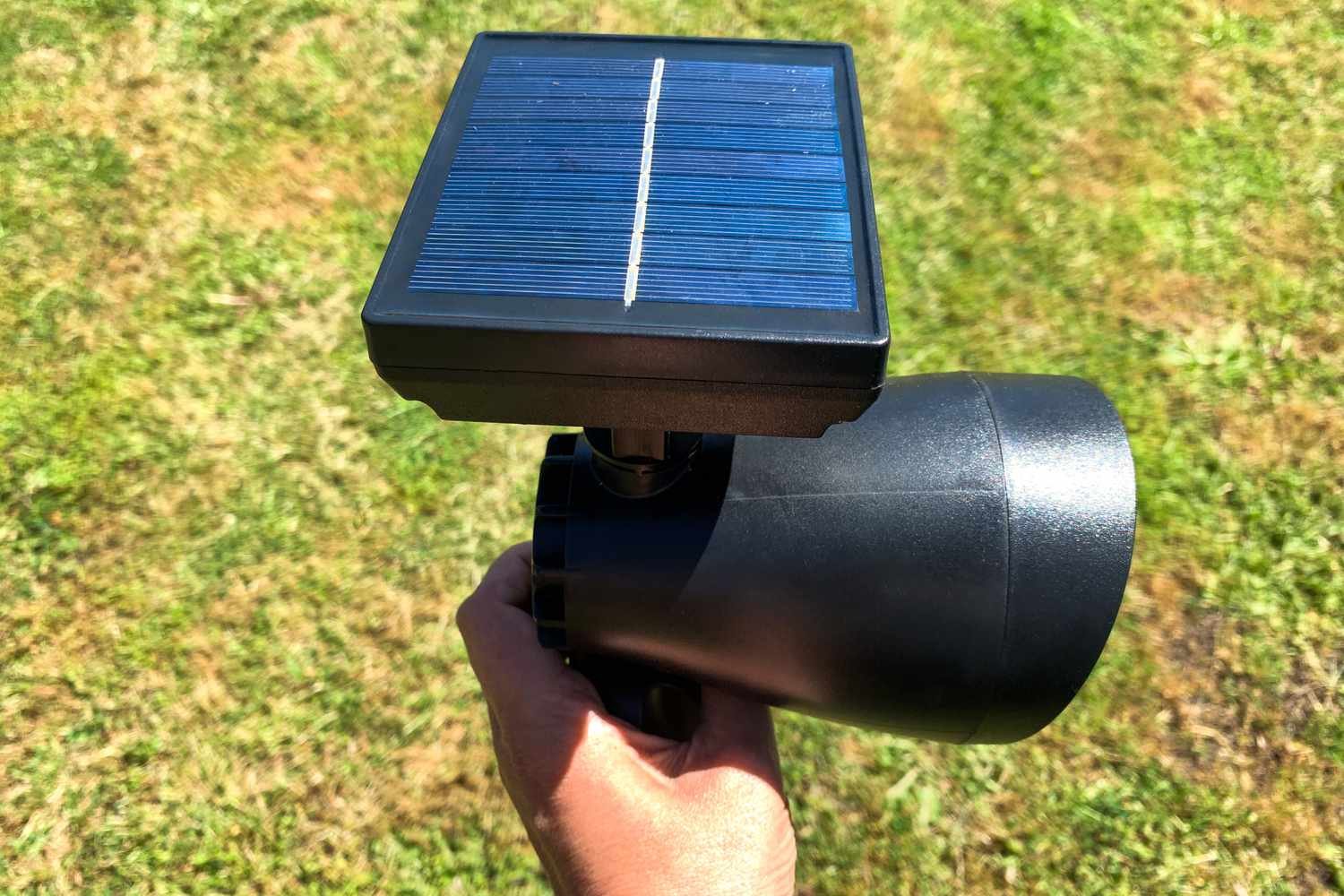 A person holds up the Hampton Bay LED Outdoor Solar Spotlight