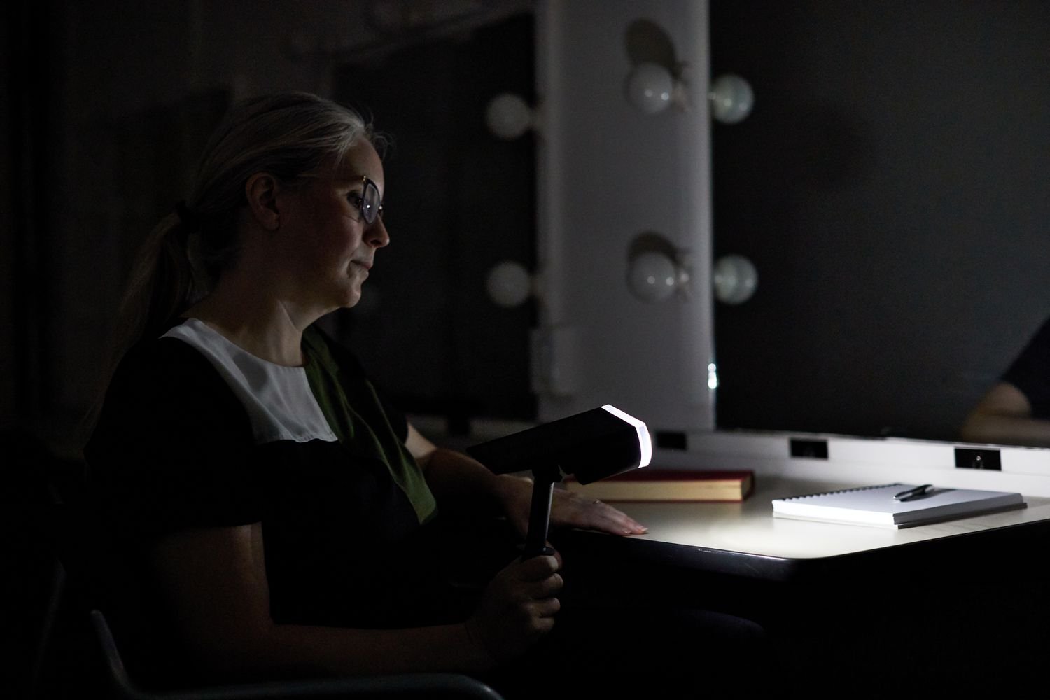 A person holding a Linkind StarRay Solar Spotlight over a table