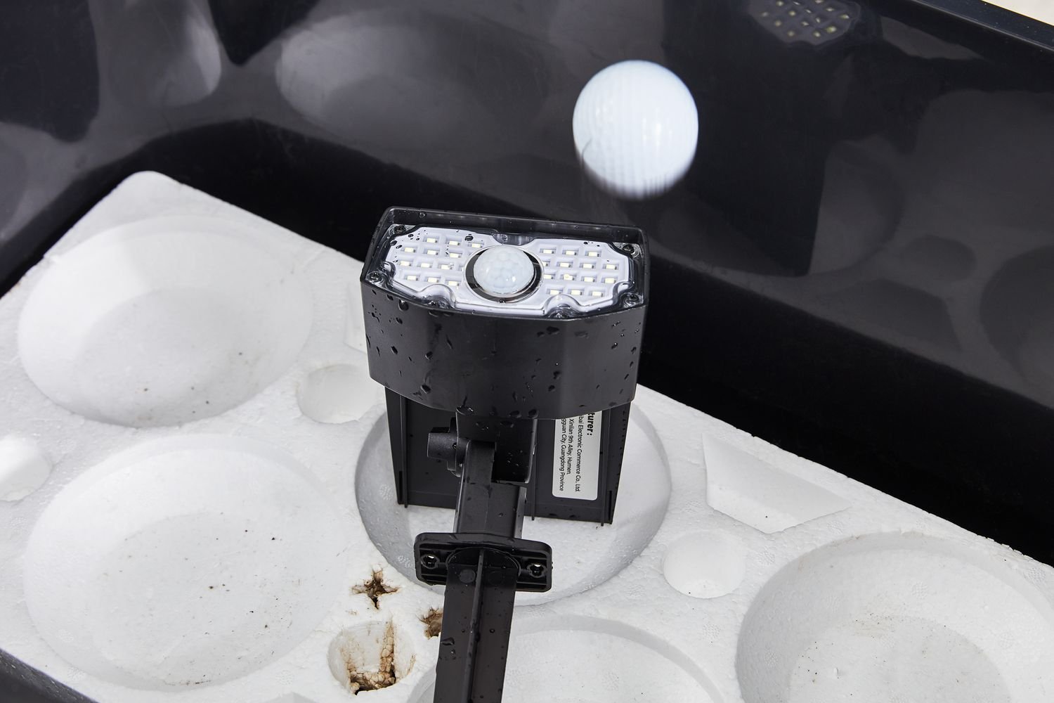 Closeup of golf ball dropping onto AloftSun Solar Motion Sensor Outdoor Lights