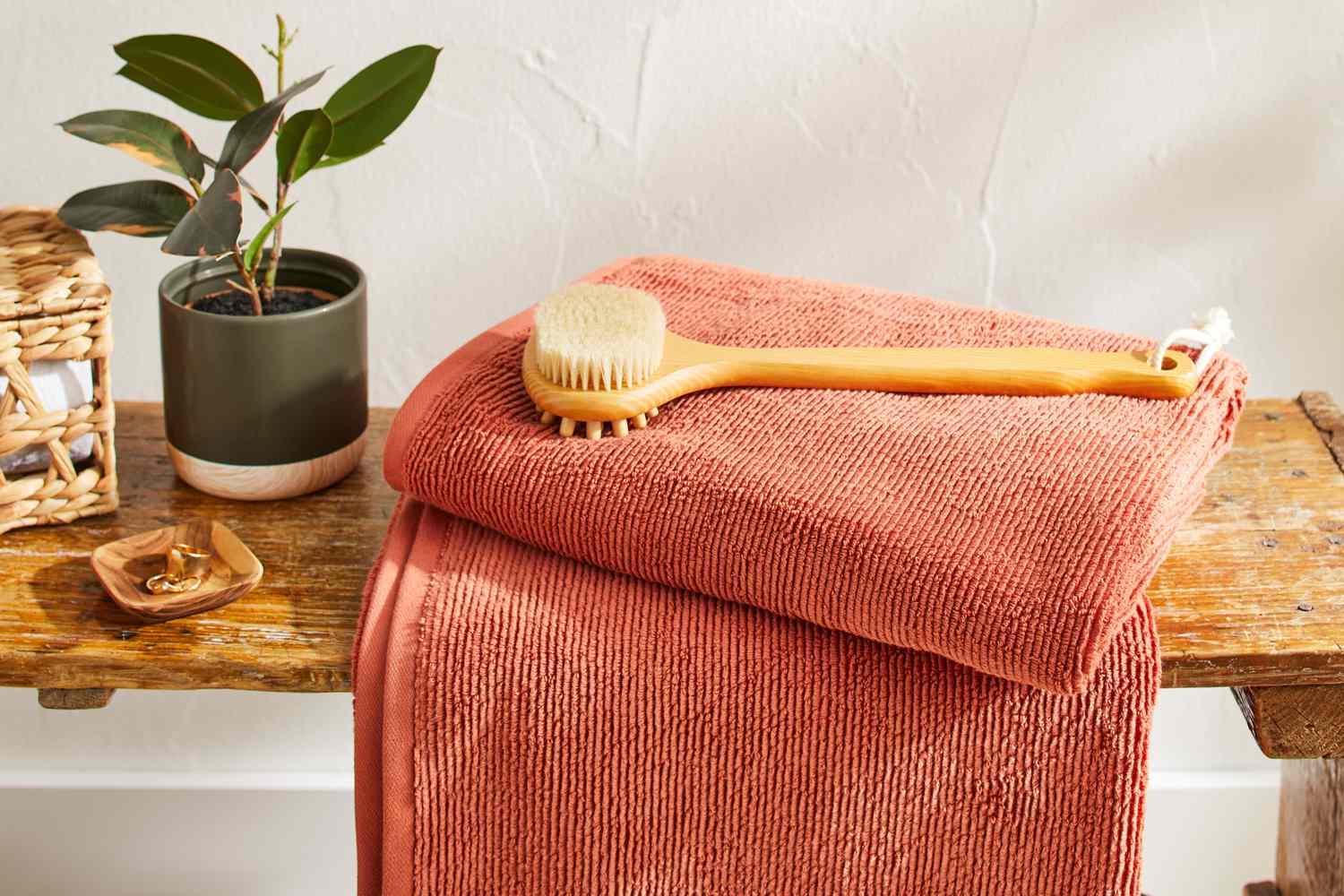 A folded Brooklinen Organic Ribbed Bath Towel on a bench in bathroom