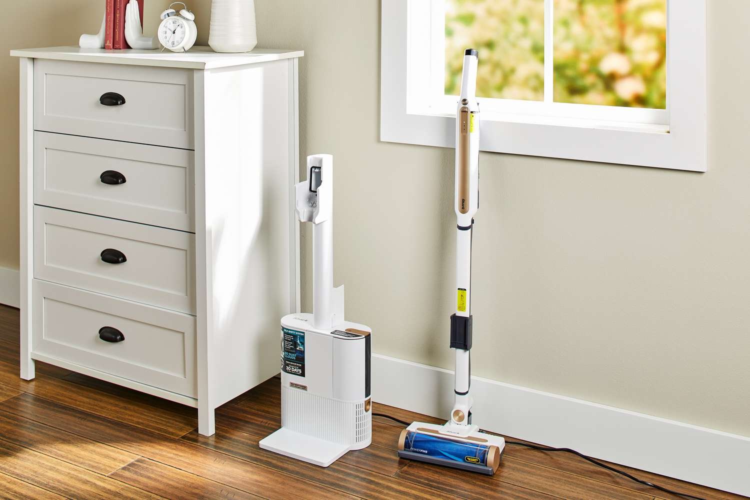Shark WS642AE Wandvac Cordless Stick Vacuum with Self-Empty Charging is leaned on wall next to cupboard 