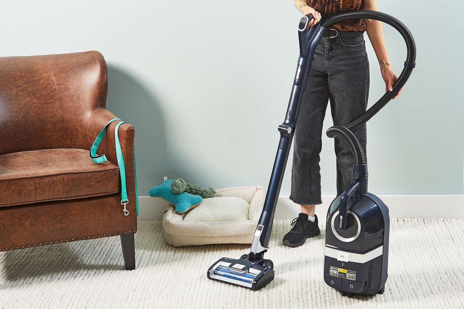 Person cleaning white carpet using the Shark Canister Pet Bagless Corded Vacuum 