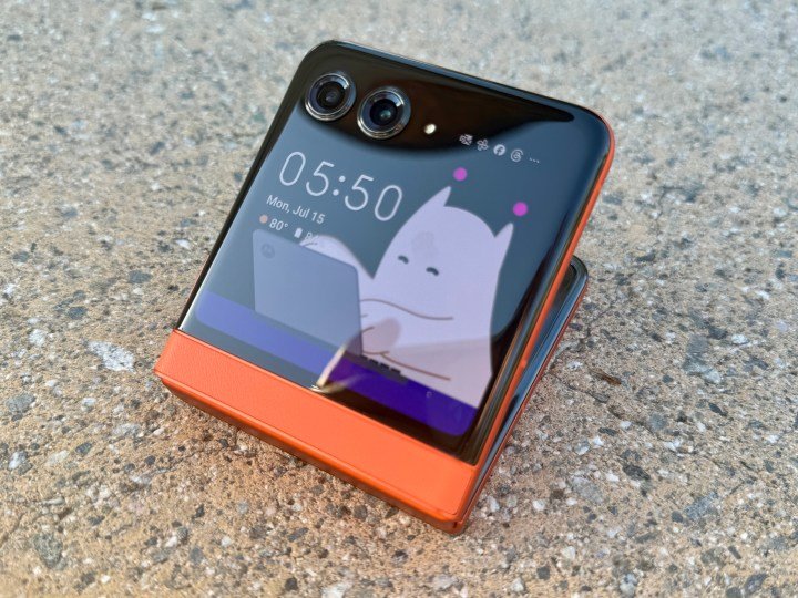 Motorola Razr 2024 in Spritz Orange showing Moo on a partial open cover display.