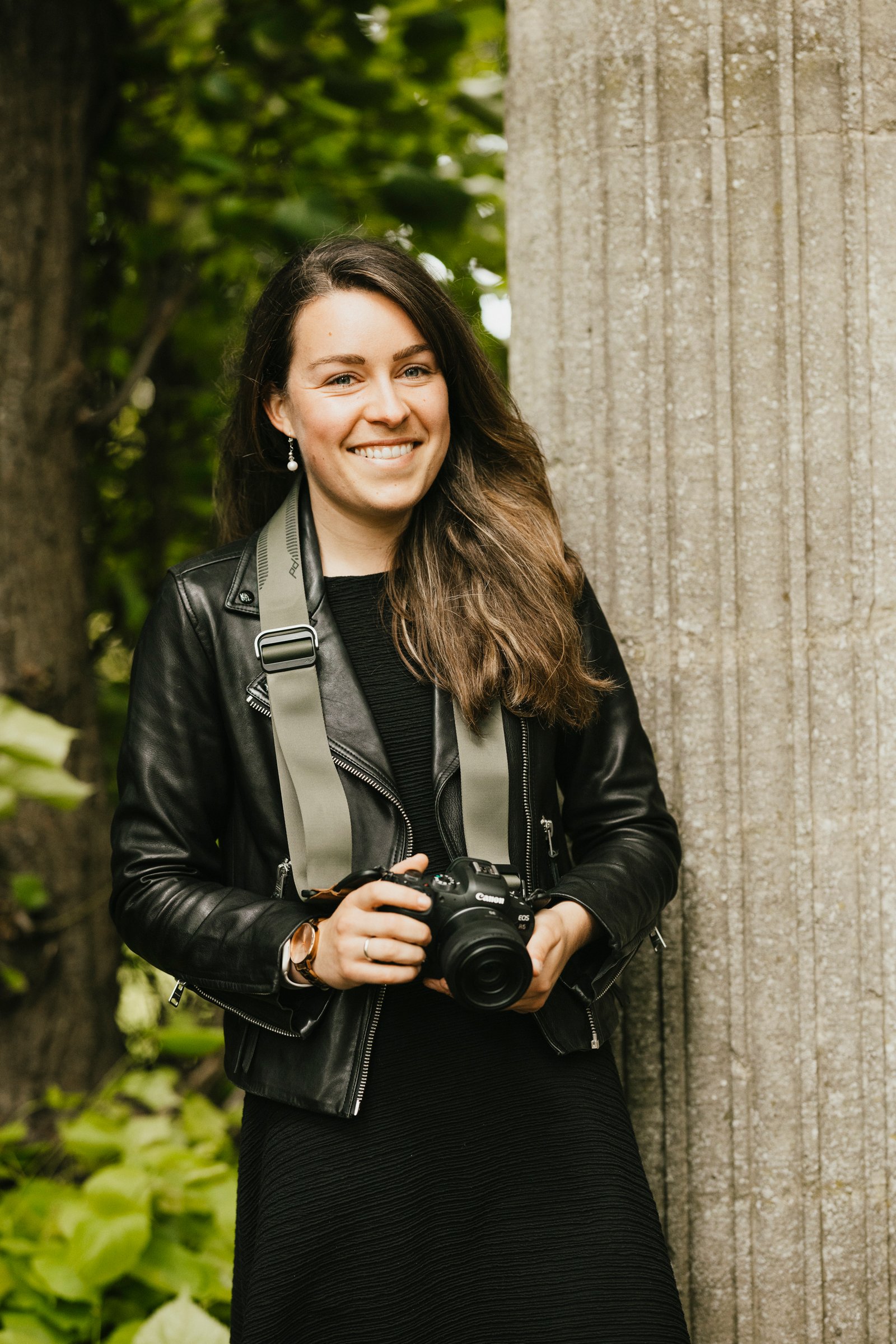 Freelancer photographer Lauren Scott holding a Canon camera in the park