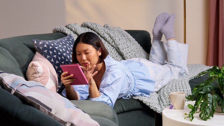 Amazon Kindle Paperwhite 2024 12th-generation pink in use while lying on stomach on a couch