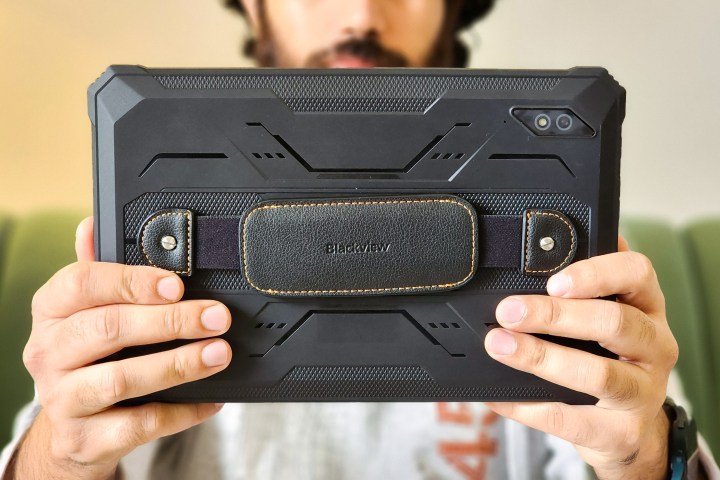 Man holds Blackview Active 8 Pro rugged Android tablet in black color with a leather strap.