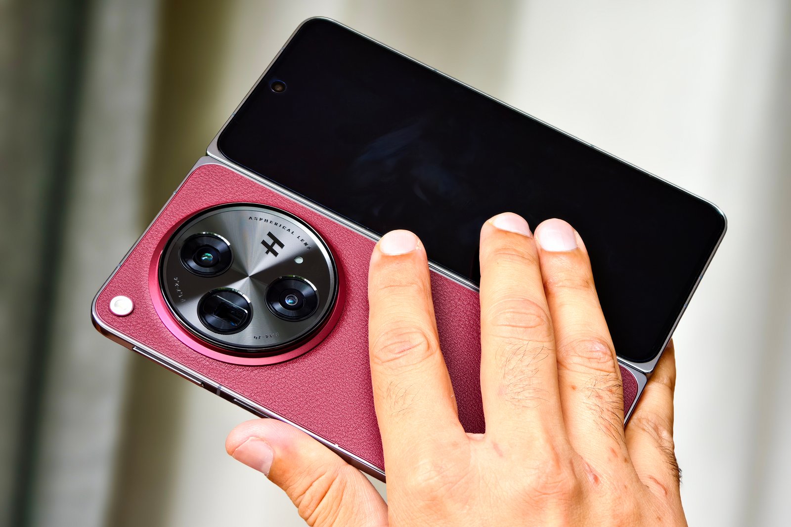 OnePlus Open Apex Edition Crimson Shadow red one held in one hand.