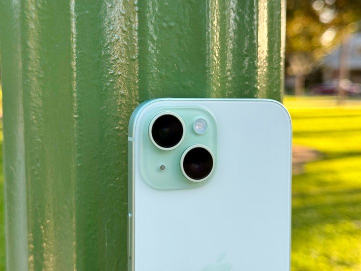 A green iPhone 15 showing the camera module.