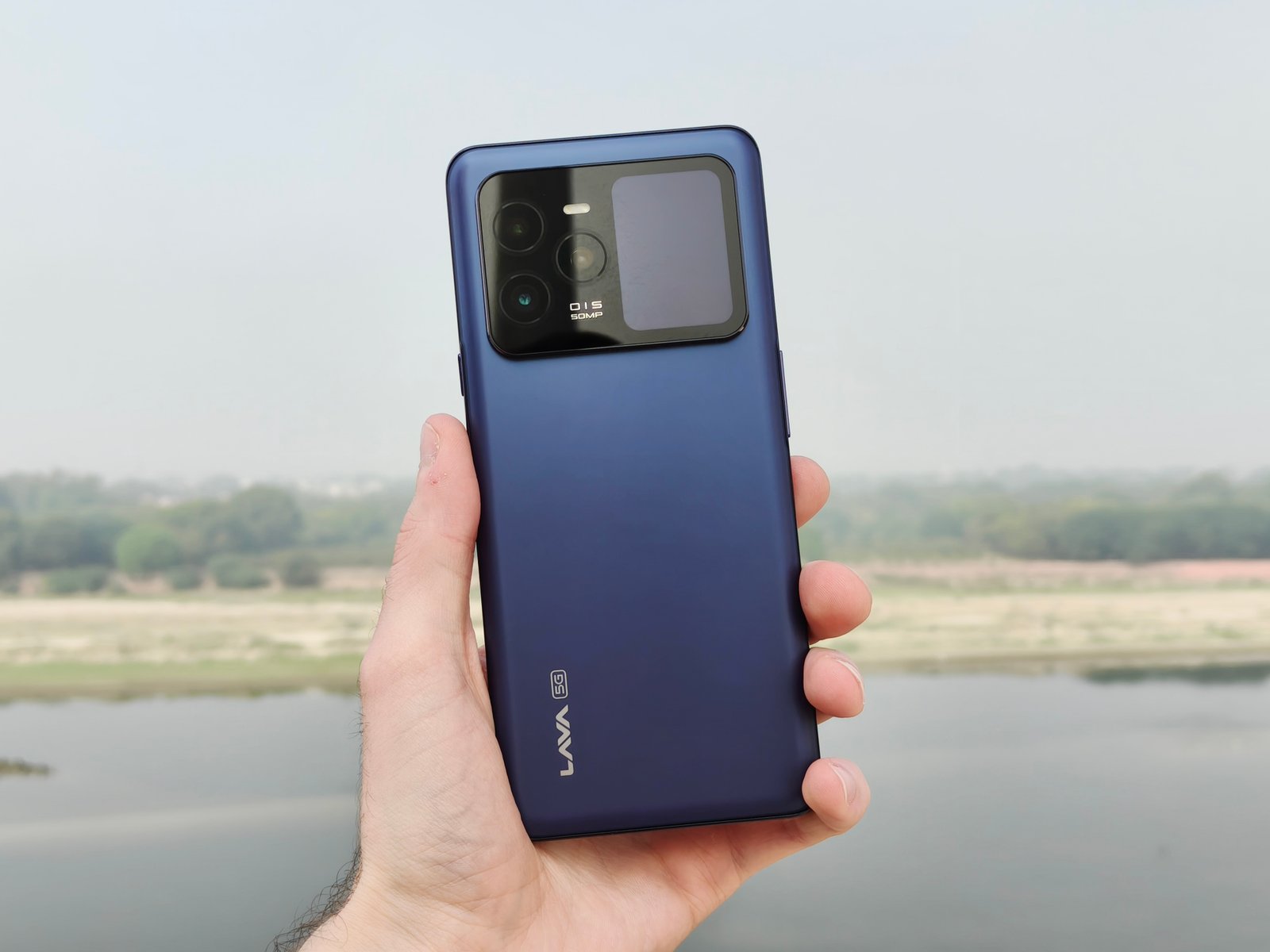 Someone holding the Lava Agni 3 smartphone, showing the back.