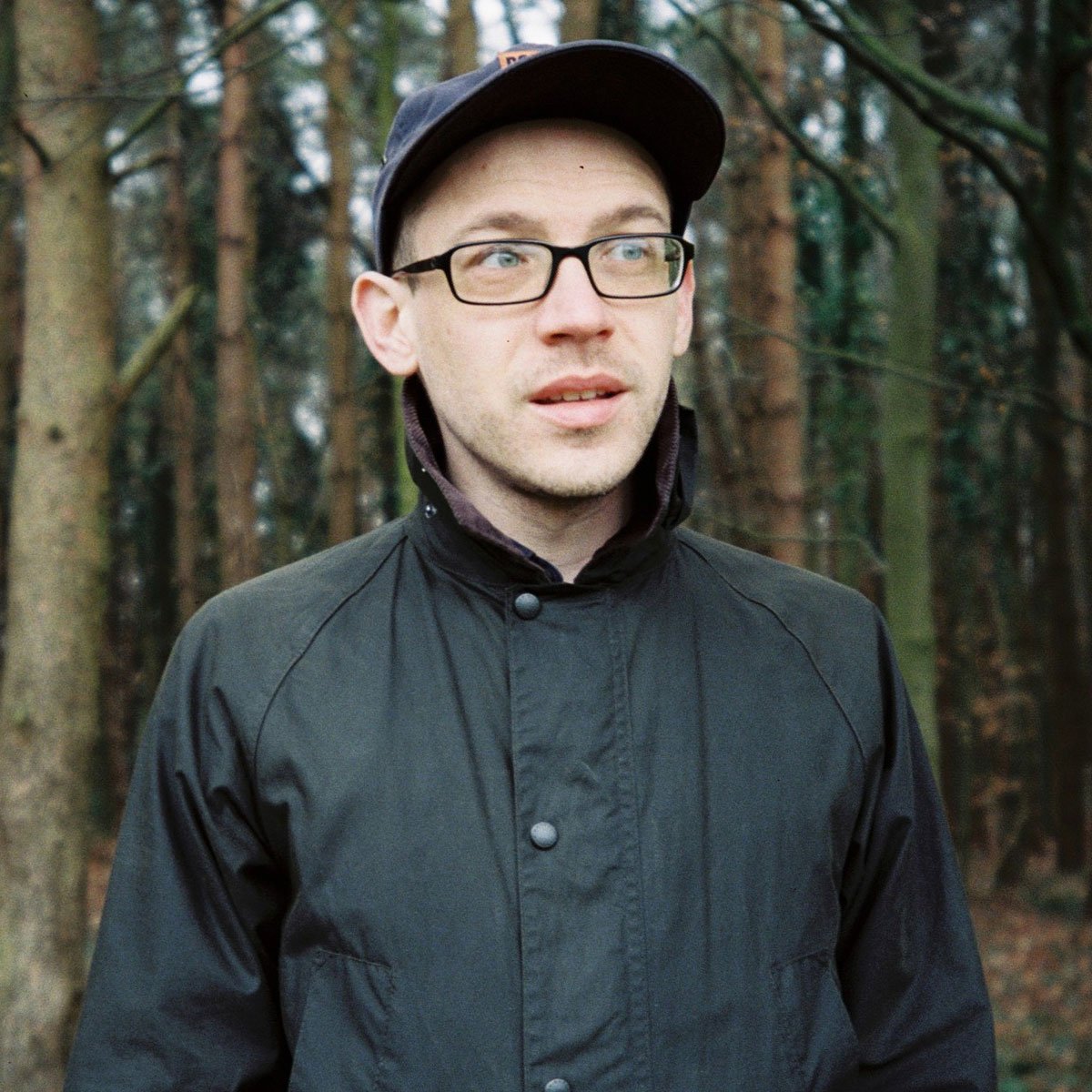 A man wearing a baseball cap in the woods