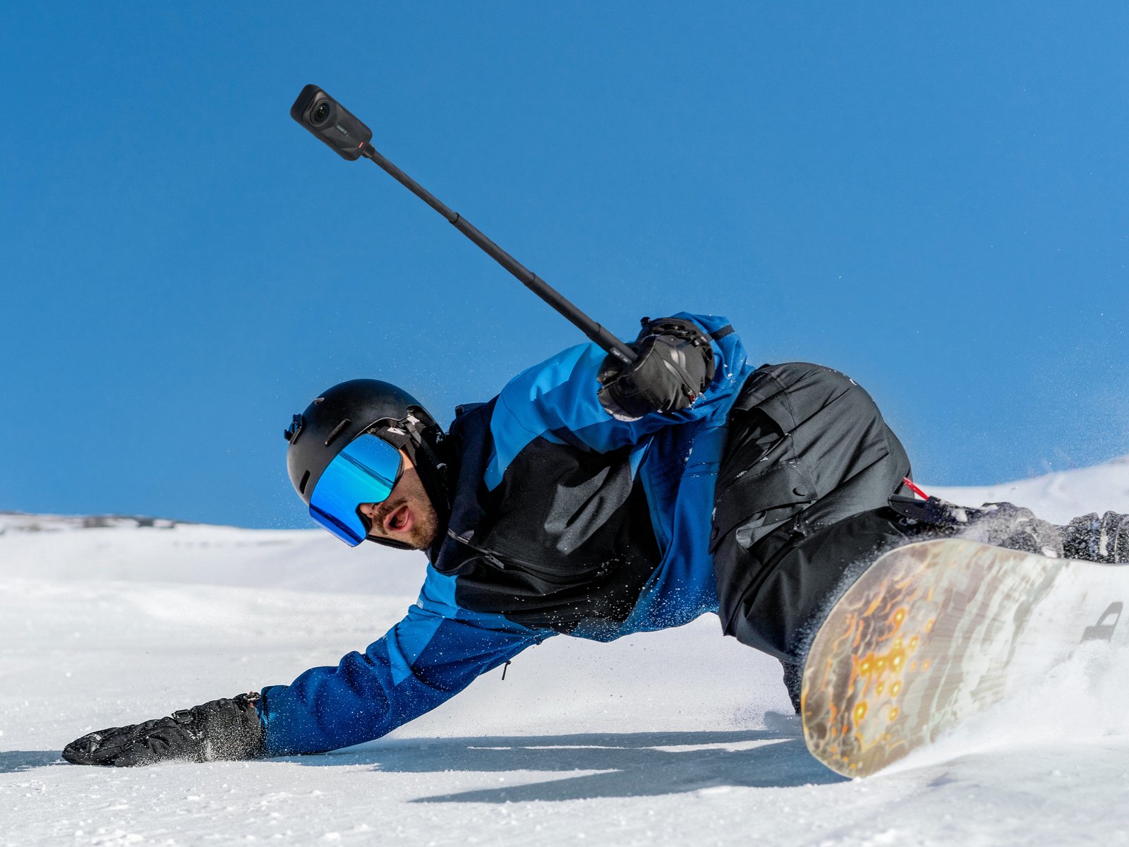 A person skiing with Insta360 X5 attached on a stick.