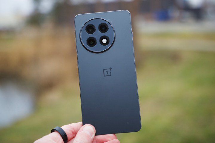 Someone holding the OnePlus 13R, showing the back of the phone.