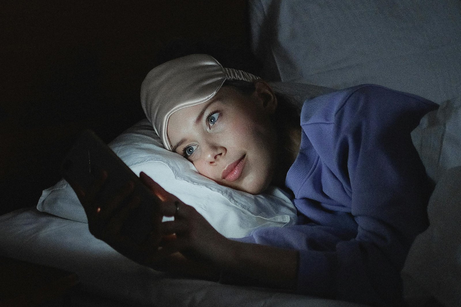 Person using a phone on bed.