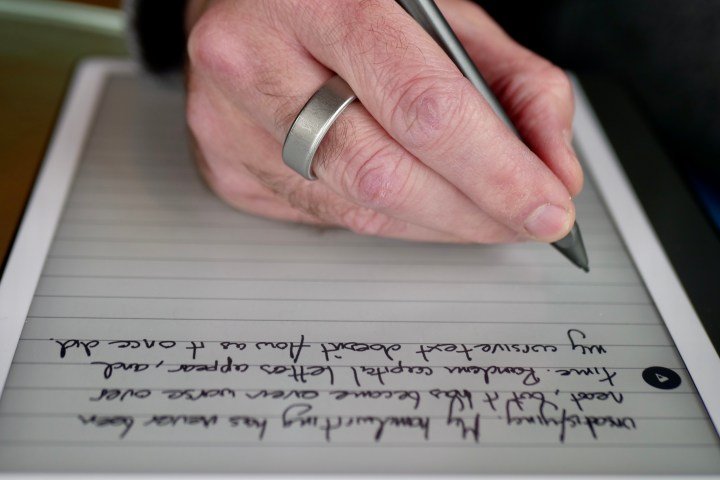A person using the Amazon Kindle Scribe and its stylus.