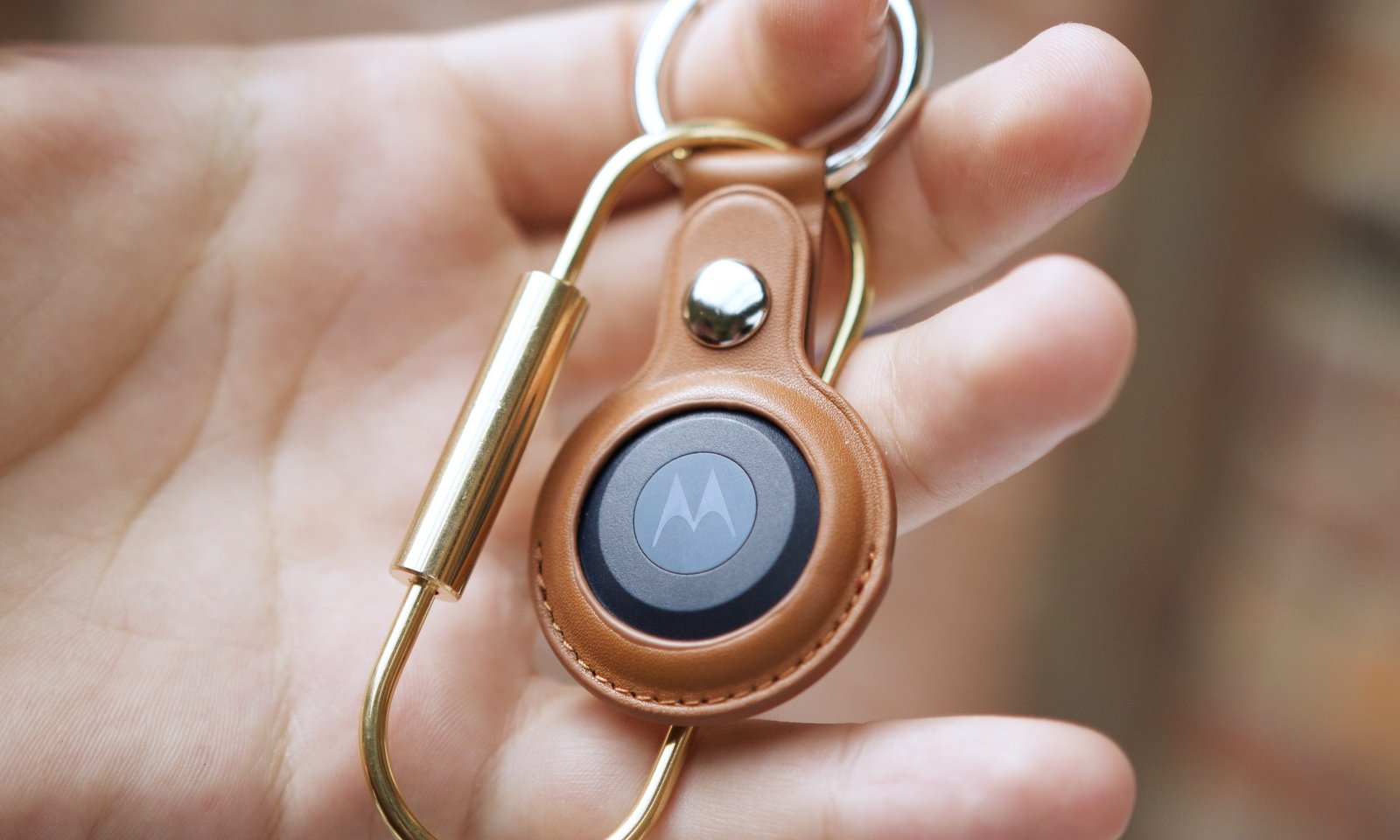 Someone holding the Moto Tag.