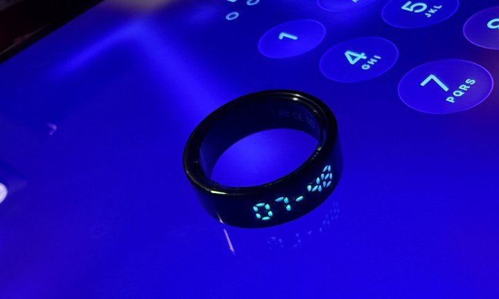 Pebble Halo smart ring lying atop a display.