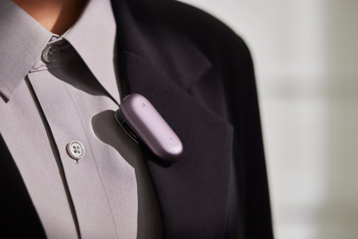 A man wearing a Plaud NotePin on this suit.