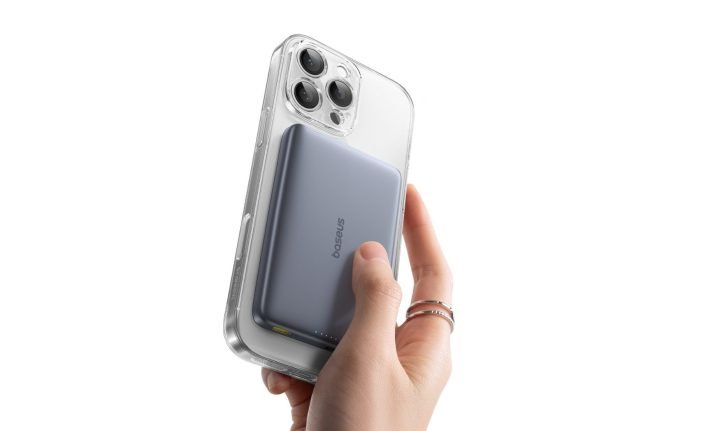 A woman holding a phone with a Baseus Am41 Magnetic Power Bank attached to it.