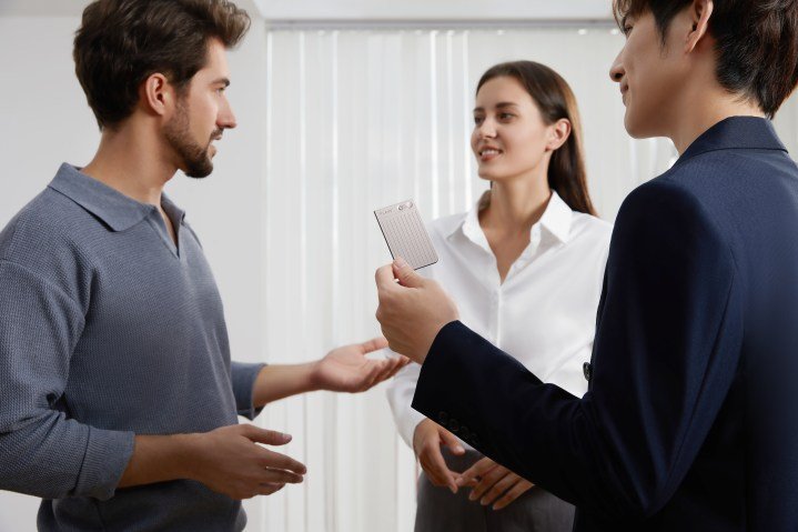 Plaud AI notetaker being used by a man to record a conversation between another man and a woman